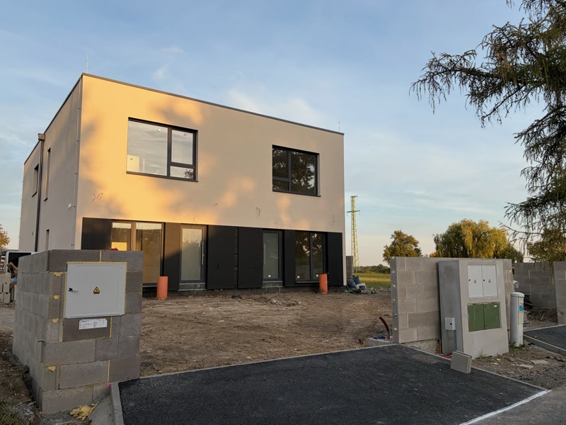 Site photo: the house from the street with the driveway and utility posts